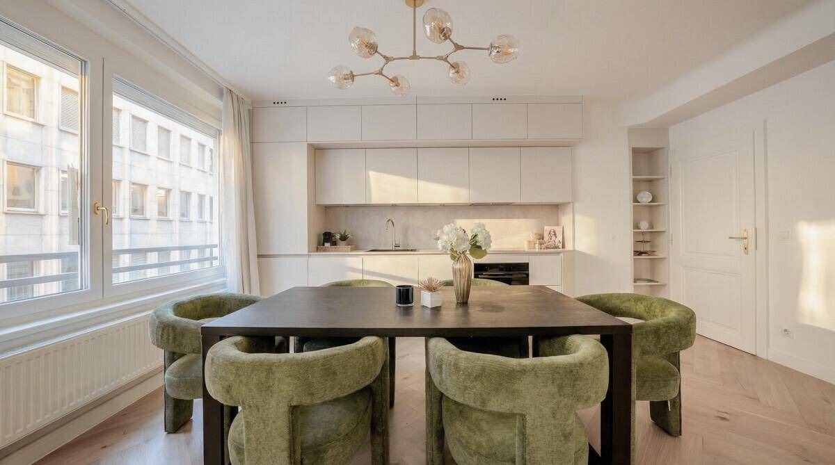 Helle, moderne Küche mit Essbereich und großen Fenstern, ideal für gesellige Abende und Kochen.