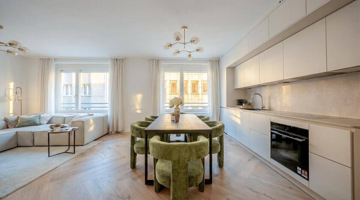 Heller, offener Wohnbereich mit integrierter Küche und Essplatz am Fenster, sehr einladend.