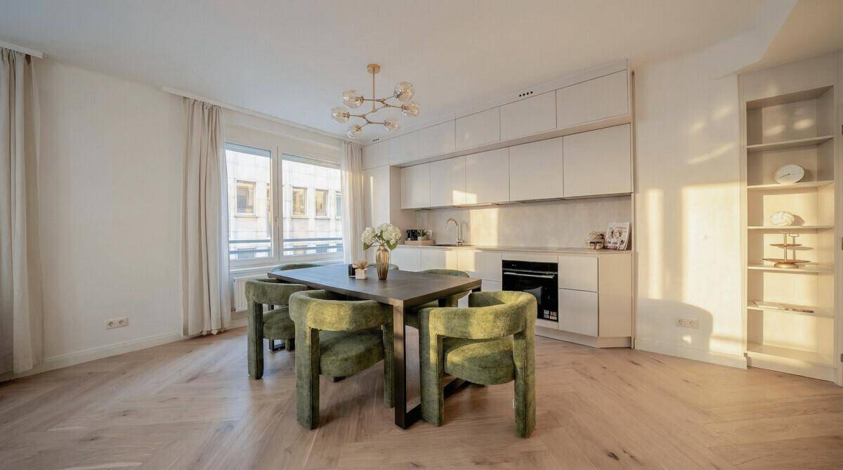 Moderne Einbauküche mit Essbereich und großen Fenstern, lichtdurchflutet und stilvoll eingerichtet.