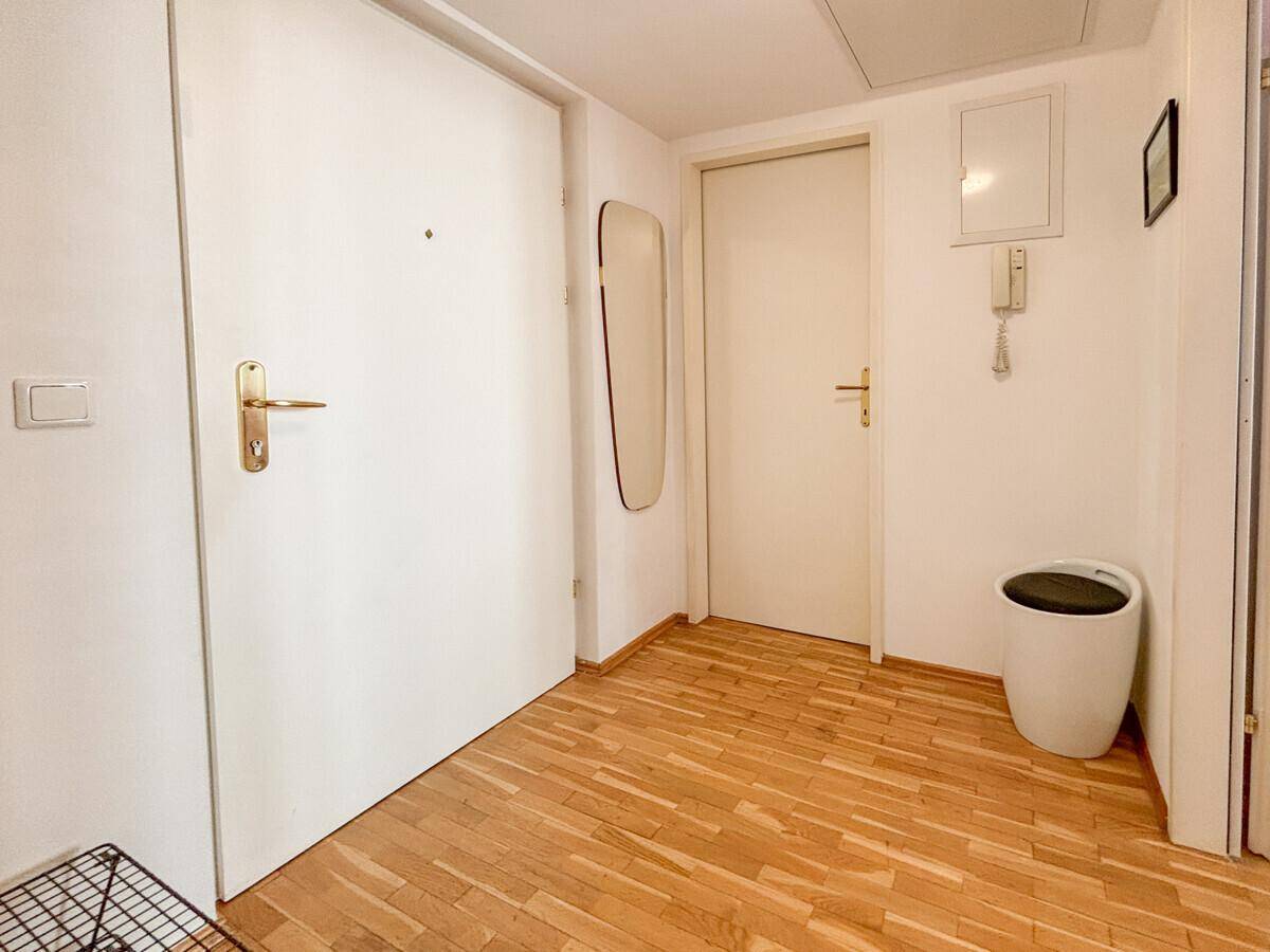 Heller Eingangsbereich mit Parkettboden, Garderobe und Gegensprechanlage.