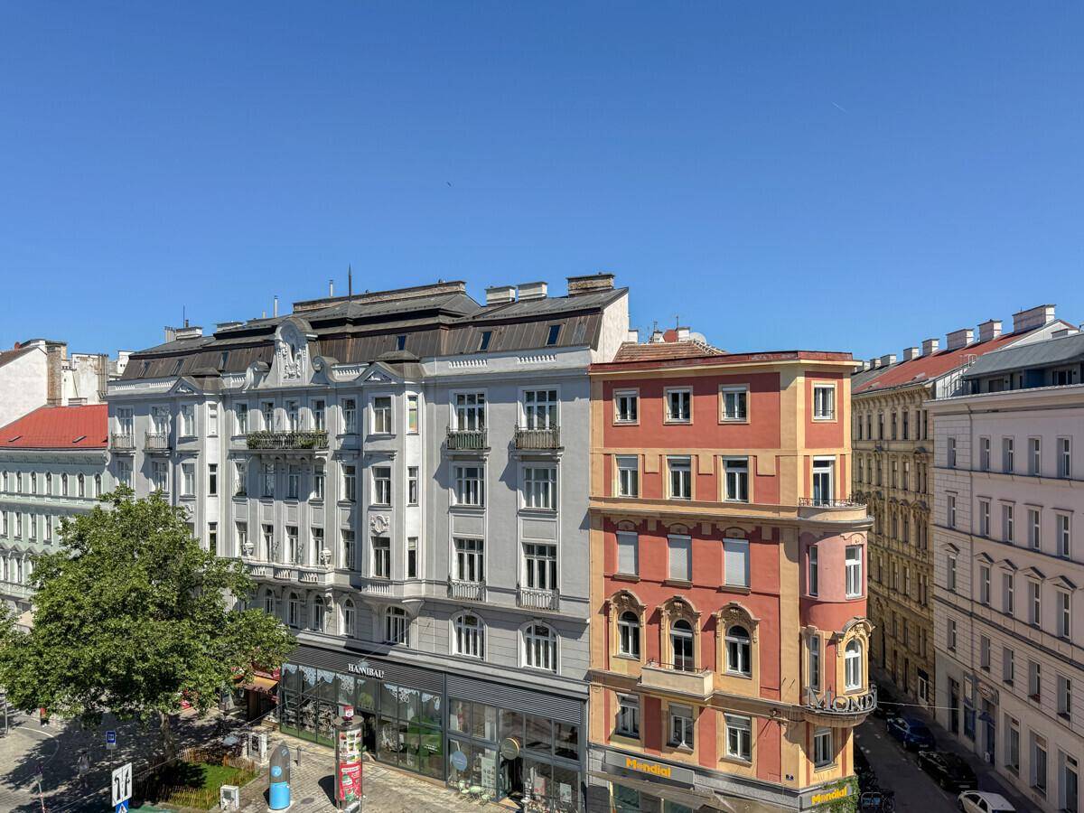 Historische Gebäude mit unterschiedlichen Fassaden entlang einer belebten Stadtstraße.