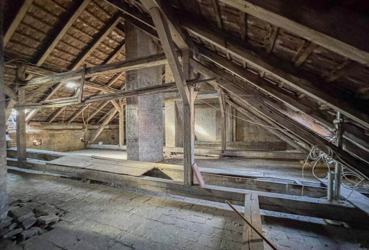 Unausgebauter Dachboden mit sichtbaren Holzbalken und Dachkonstruktion, ideal für Ausbauprojekte.