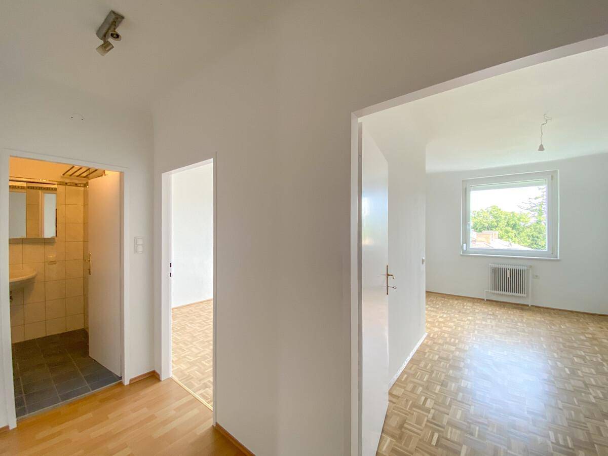 Heller Flur mit Parkettboden, der zu verschiedenen Zimmern und dem Badezimmer führt.