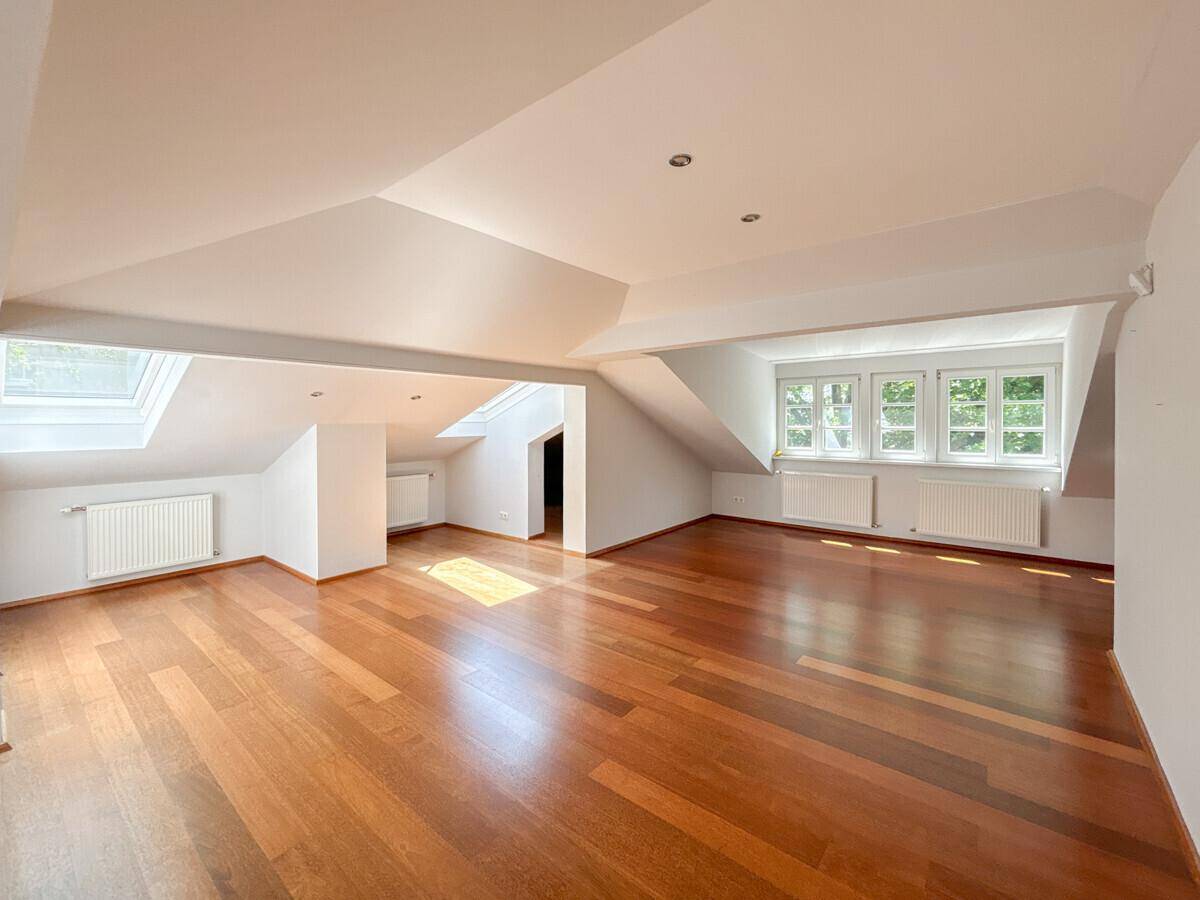 Helles Dachgeschosszimmer mit Holzboden, Dachfenstern und viel natürlichem Licht.