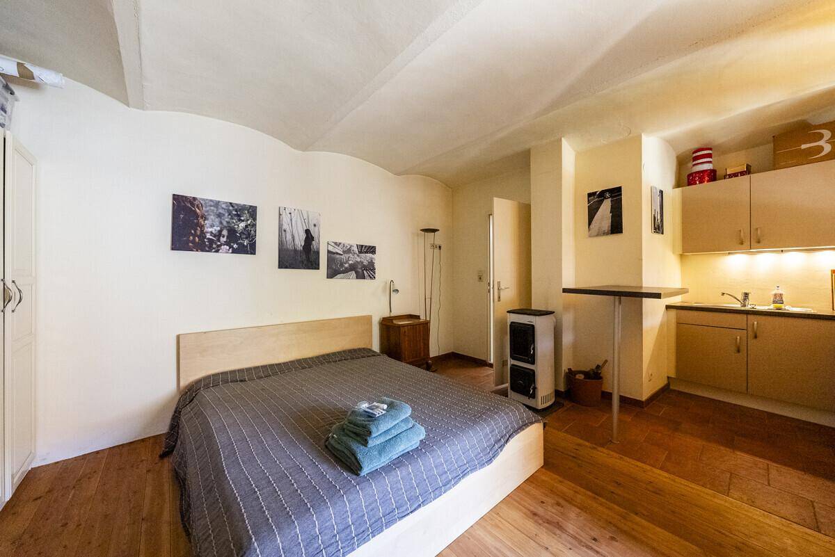 Schlafzimmer mit Doppelbett, integrierter Küchenzeile und gewölbter Decke, ideal für Gäste.