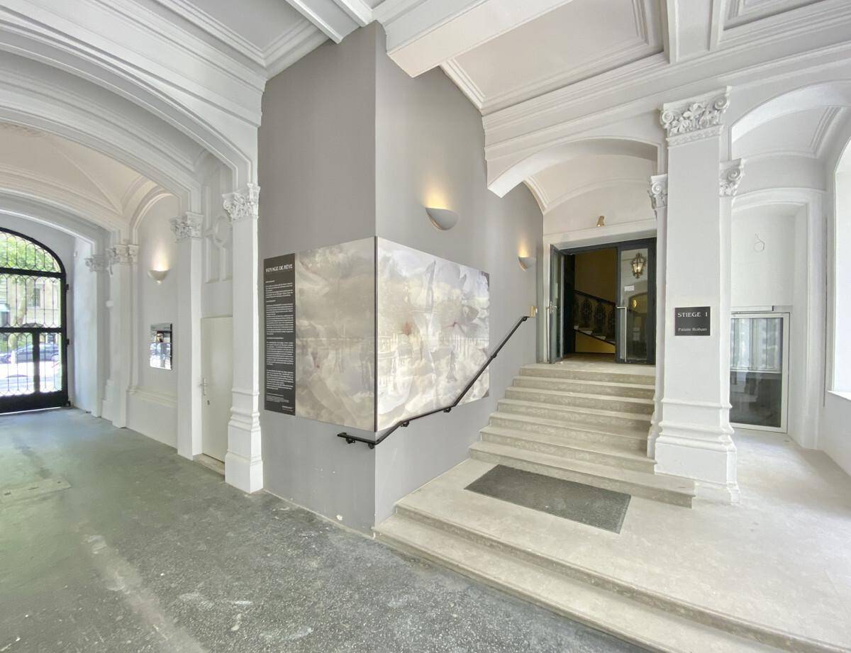 Großzügiger Eingangsbereich mit hohen Gewölbedecken, eleganten Bögen und einer breiten Treppe.