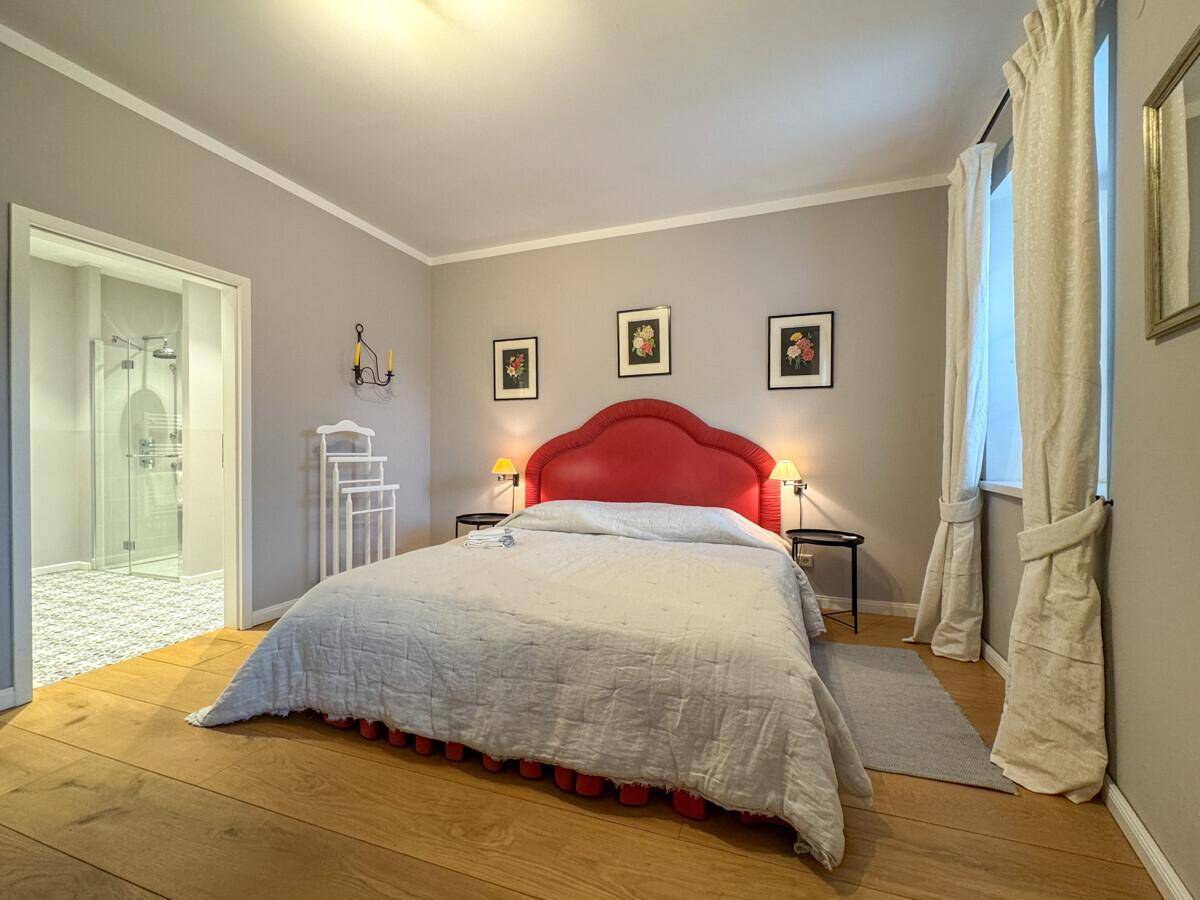 Schlafzimmer mit Doppelbett und direktem Zugang zu einem modernen Ensuite-Badezimmer.