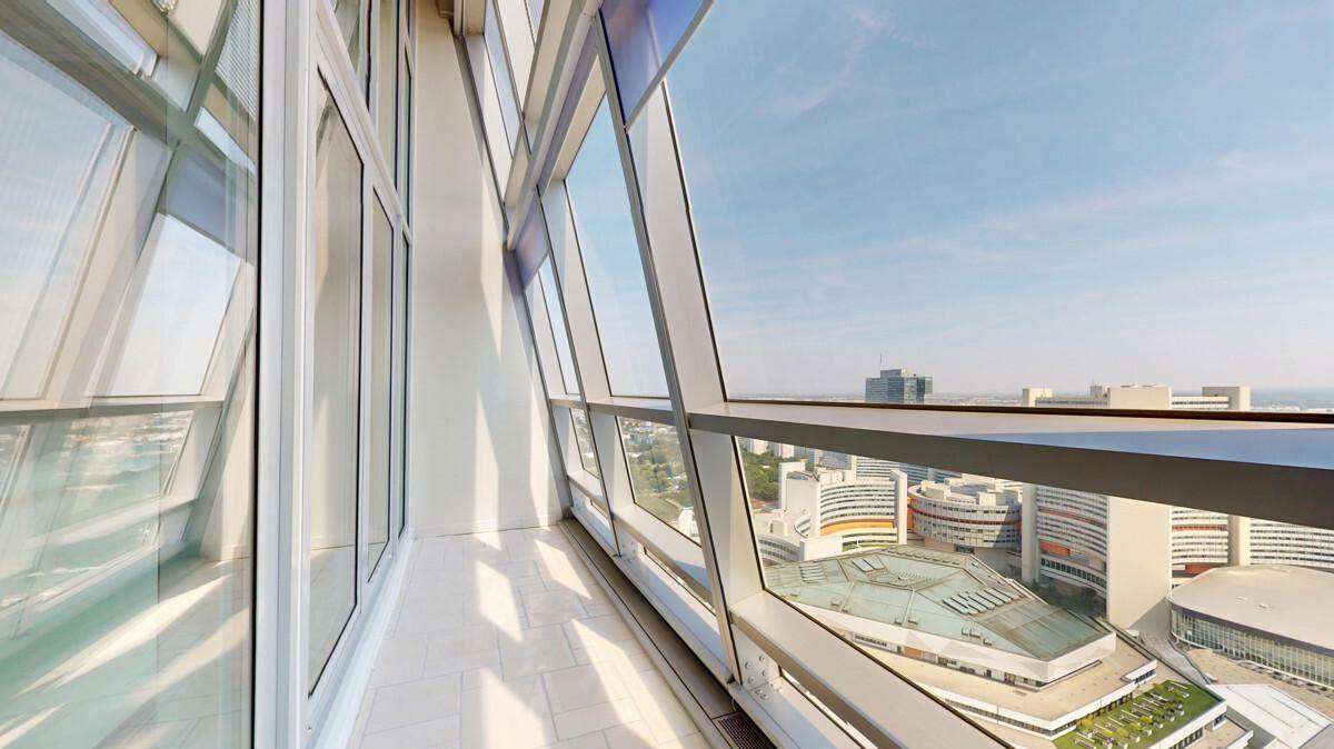 Verglaste Loggia mit Fliesenboden und beeindruckendem Panoramablick auf die Stadt.