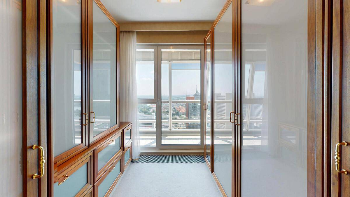 Geräumiger begehbarer Kleiderschrank mit Einbauschränken und Fenster.