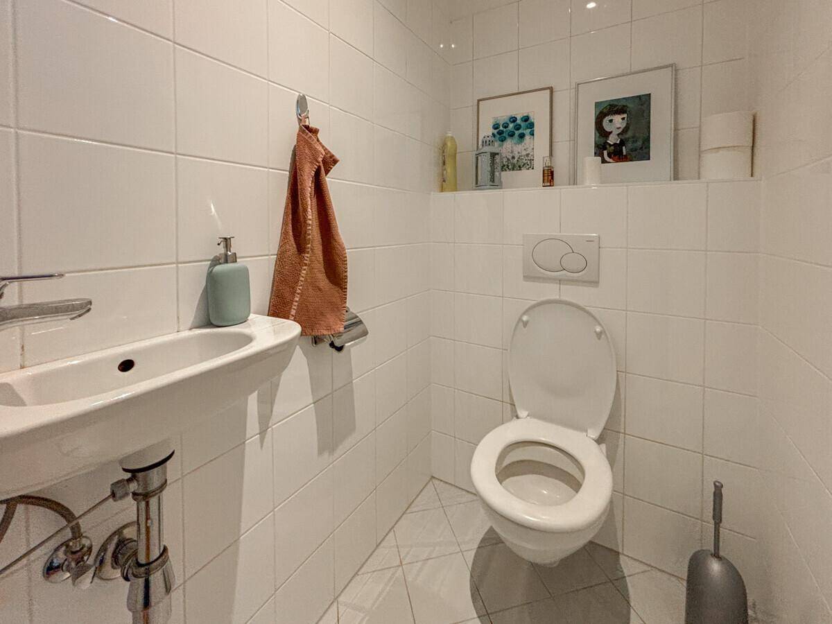 Kleines Gäste-WC mit wandhängender Toilette und Handwaschbecken.