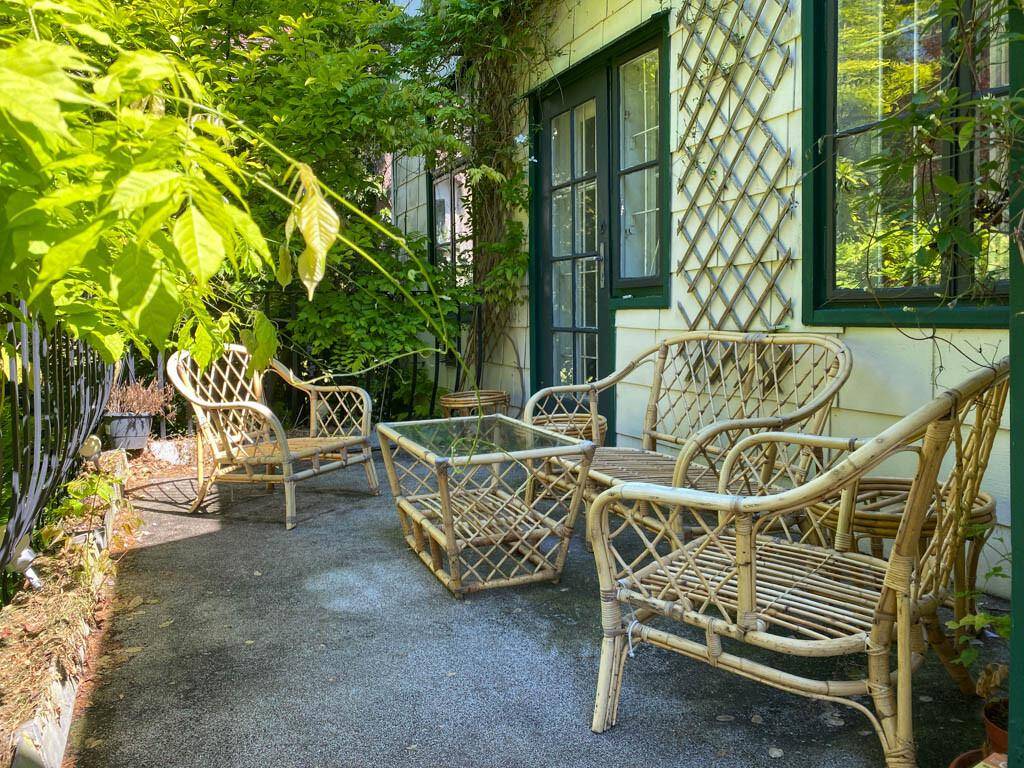 Gemütliche Terrasse mit Rattanmöbeln und Kletterpflanzen, ideal für entspannte Stunden im Freien.