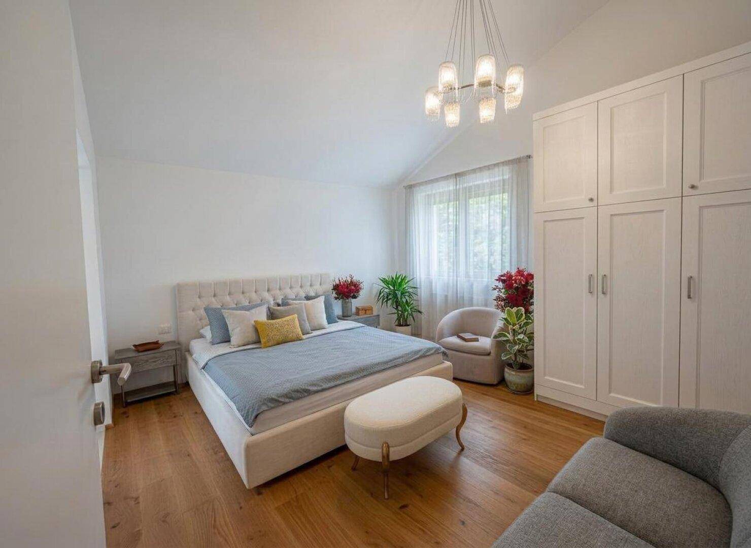 Gemütliches Schlafzimmer mit Holzboden, großem Bett und Einbauschränken in hellem Design.