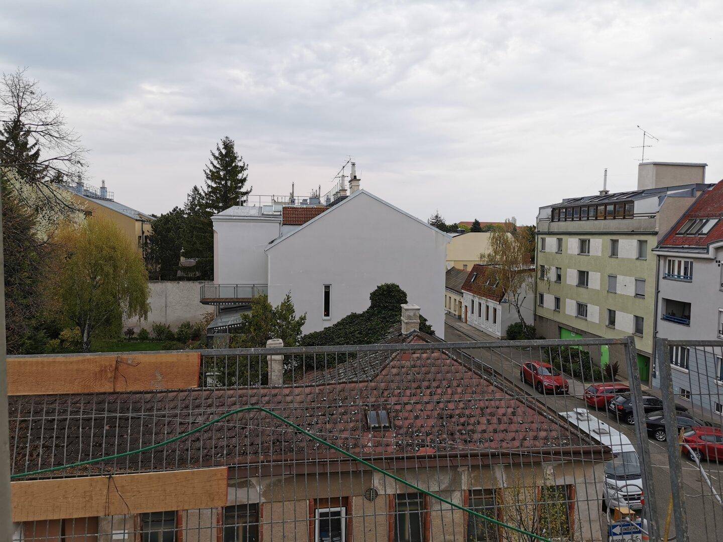 Blick über Dächer und umliegende Gebäude in einer städtischen Wohngegend.
