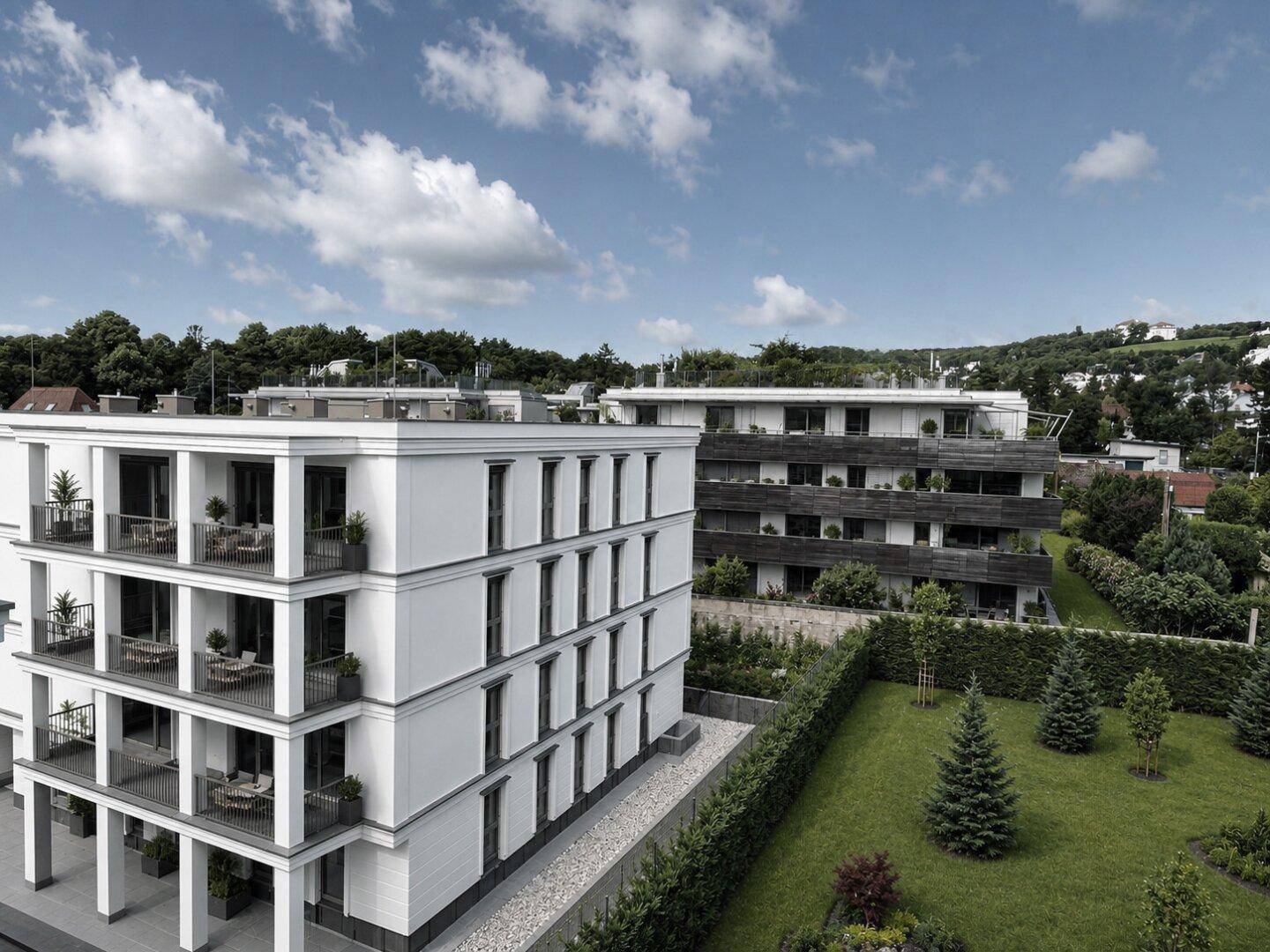 Moderne Wohngebäude mit Balkonen, großen Fenstern und gepflegter Grünanlage in ländlicher Umgebung.