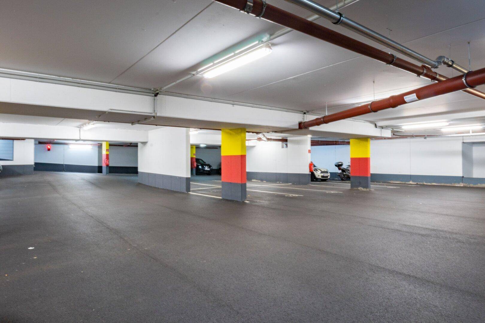 Geräumige Tiefgarage mit vielen Parkmöglichkeiten und klarer Beleuchtung.