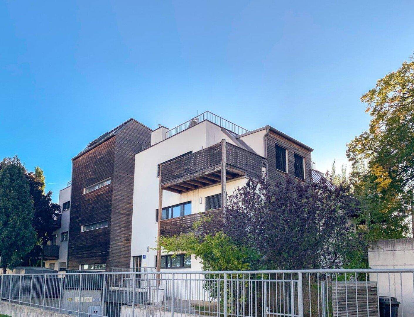 Ansicht des modernen Mehrfamilienhauses mit Holzfassade und klaren Linien.