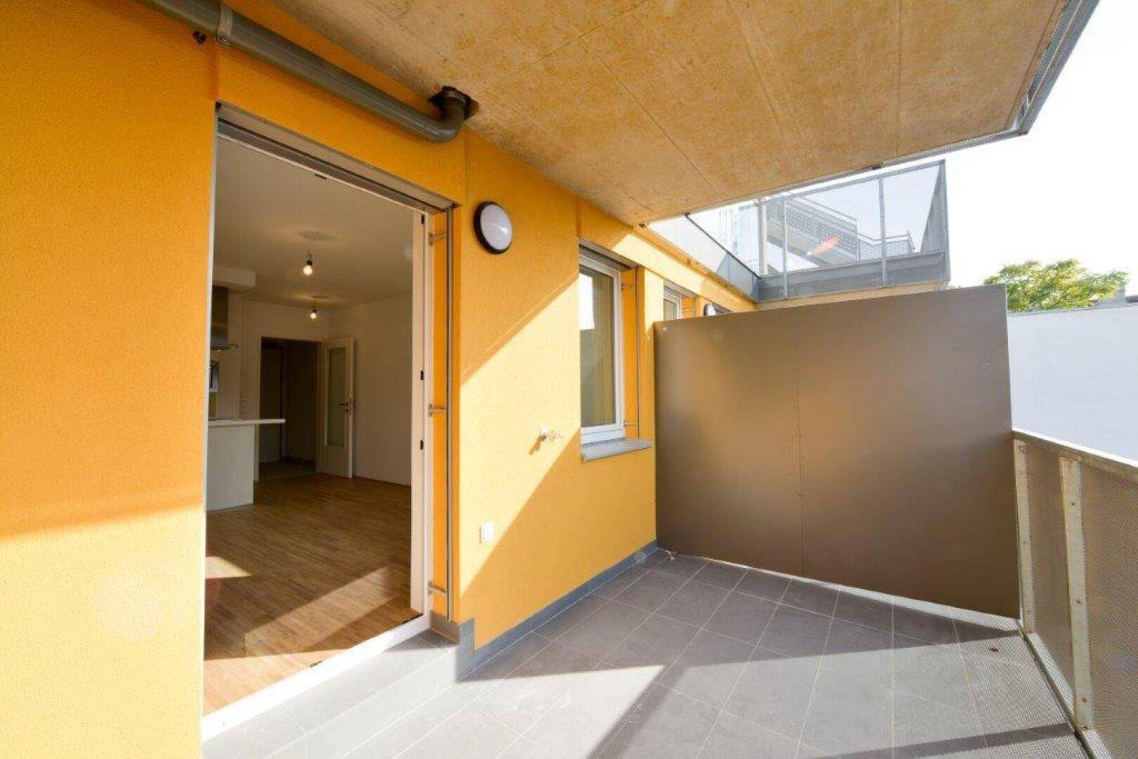 Geräumiger Balkon mit Fliesenboden und direktem Zugang vom Wohnbereich.