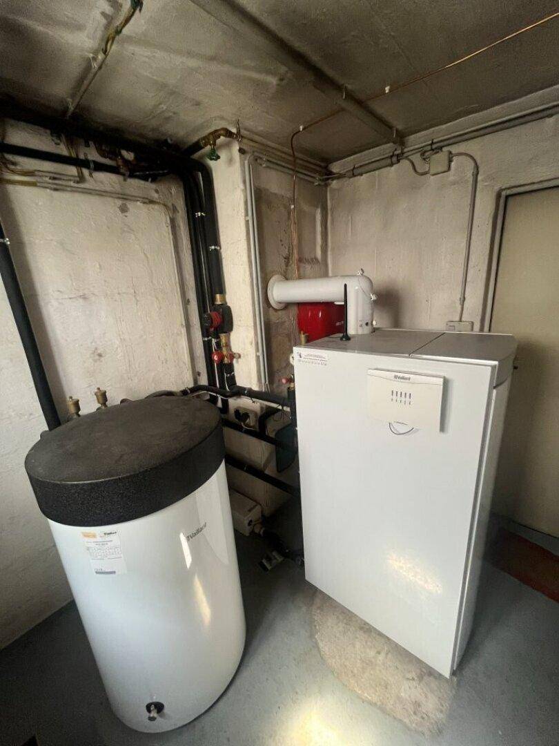 Heizungsraum im Keller mit Warmwasserspeicher und Heizungsanlage.