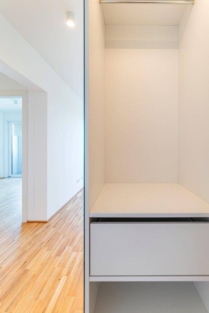Heller Einbauschrank mit Regal und Schublade im Flurbereich, mit Holzboden.