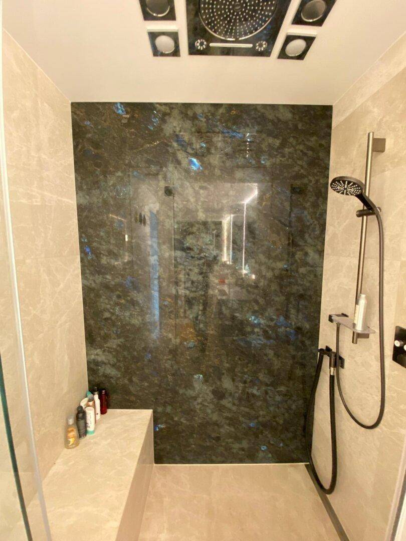 Geräumige begehbare Dusche mit luxuriösen Fliesen und Regenduschkopf.