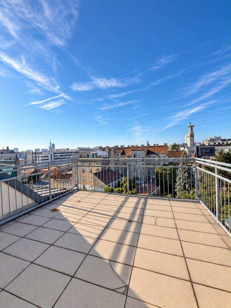 Sonniger Dachterrassenbereich mit weitem Blick über die Dächer der Stadt.
