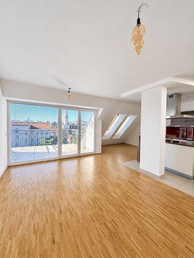 Heller Wohnbereich mit großen Fenstern, Holzboden und Blick auf die Stadt.