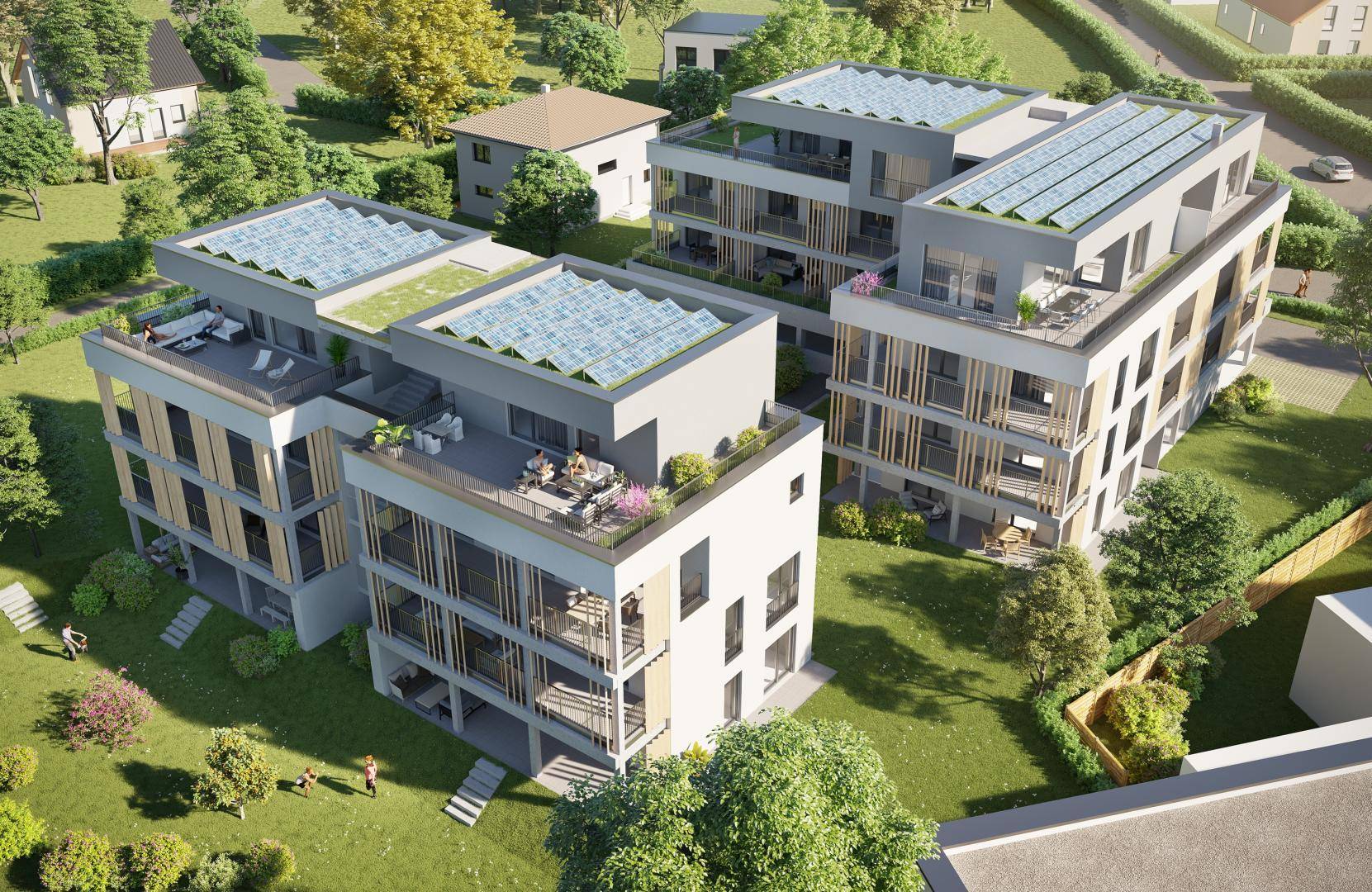 Luftaufnahme einer modernen Wohnanlage mit mehreren Gebäuden, Flachdächern und großzügigen Grünflächen.