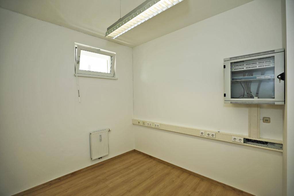 Kleiner Raum mit Laminatboden, Fenster und einem Serverschrank, ideal für technische Ausstattung.
