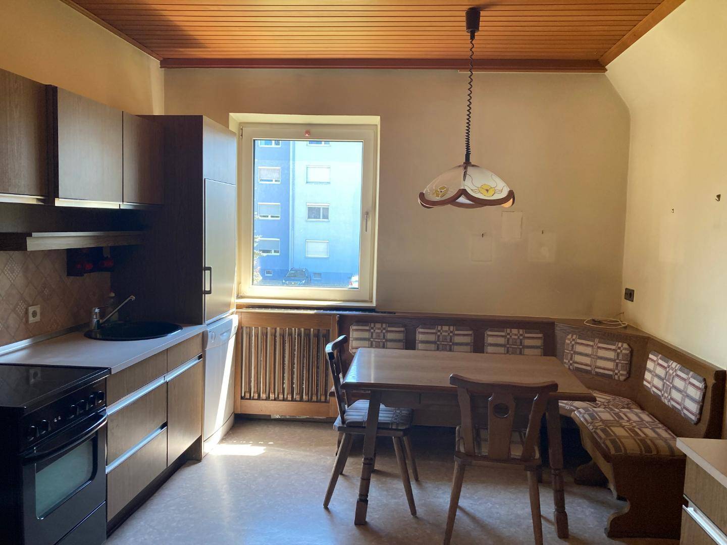 Heller Essbereich in der Küche mit Eckbank, Holztisch und Blick ins Grüne.