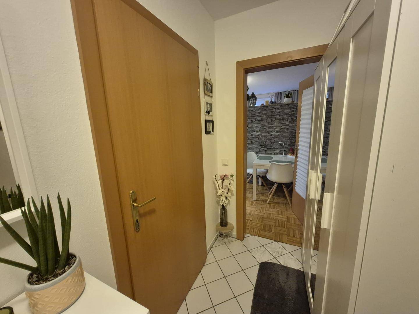 Eingangsbereich mit Fliesenboden und Blick in den angrenzenden Wohnbereich.