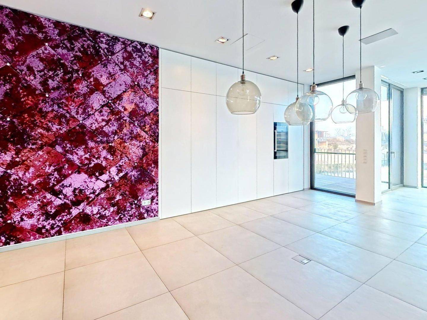 Moderner Wohnbereich mit auffälliger lila Wandgestaltung und stilvollen Hängelampen.