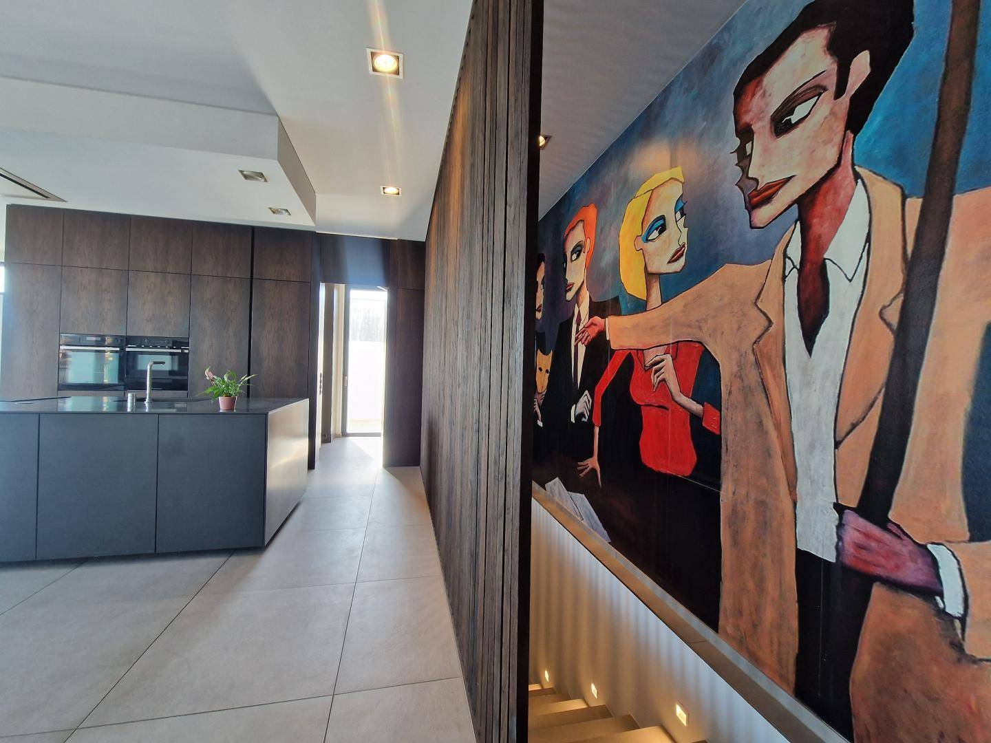 Moderner Flur mit Holzwandverkleidung, integrierter Küche und künstlerischer Wandmalerei.