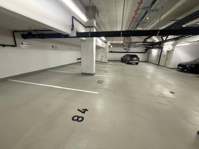Geräumige Tiefgarage mit markierten Stellplätzen und guter Beleuchtung.