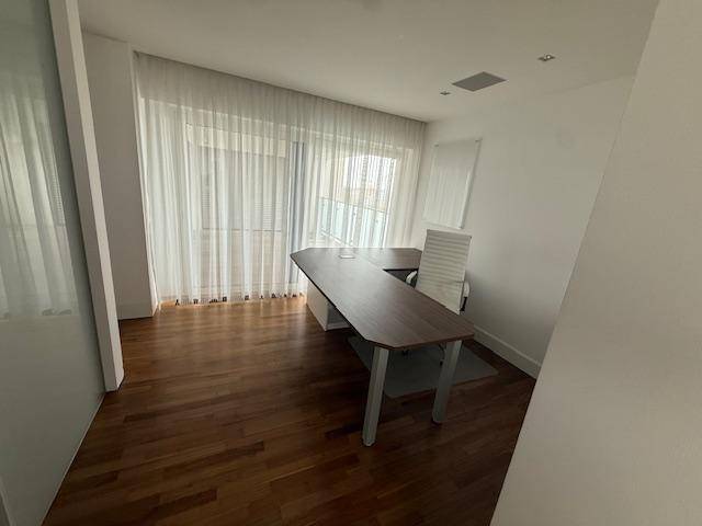 Helles Arbeitszimmer mit Holzboden und großen Fenstern für viel Tageslicht.