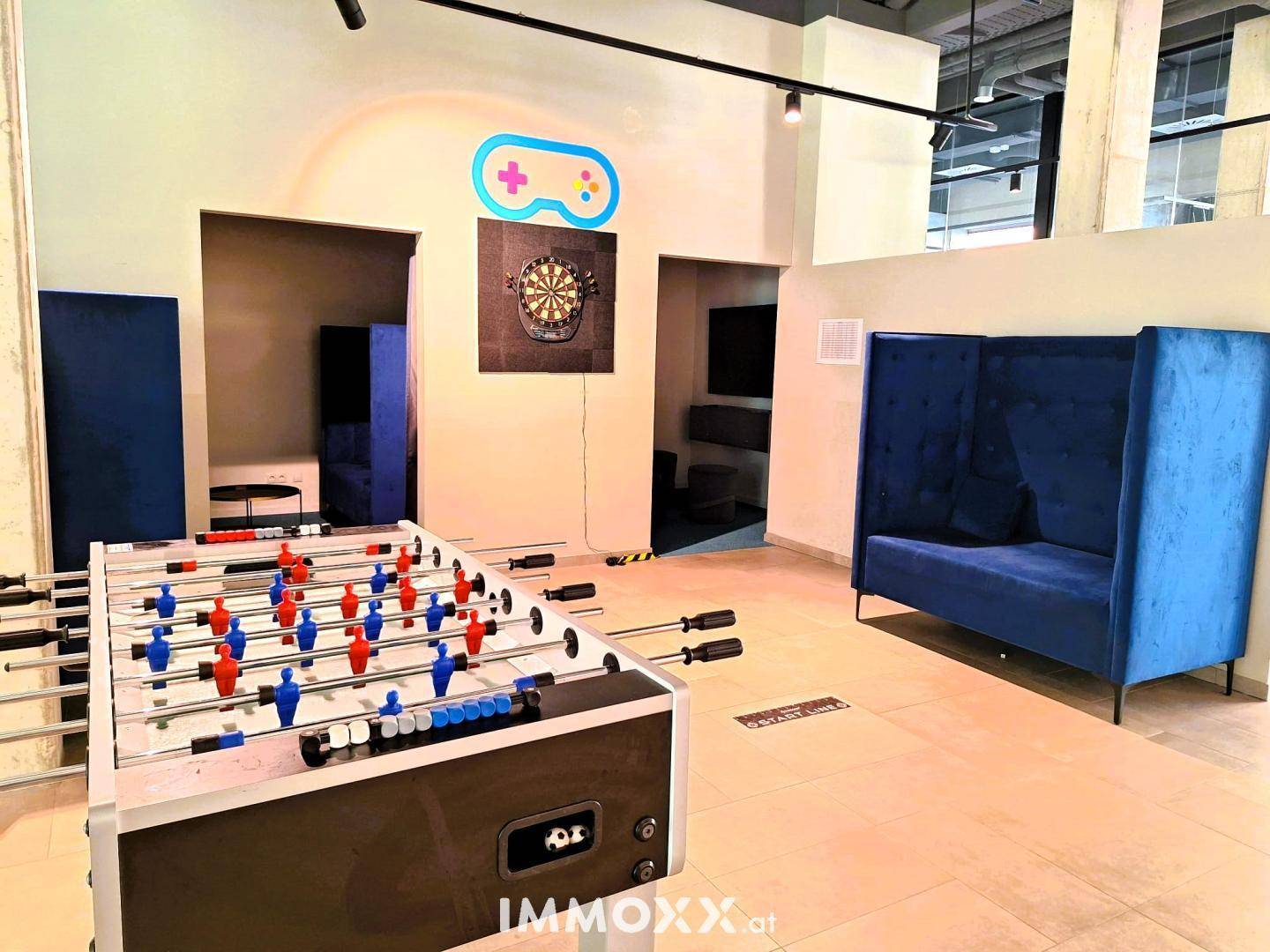 Lebhaftes Spielzimmer mit Tischfußball und bequemen Sitzgelegenheiten.