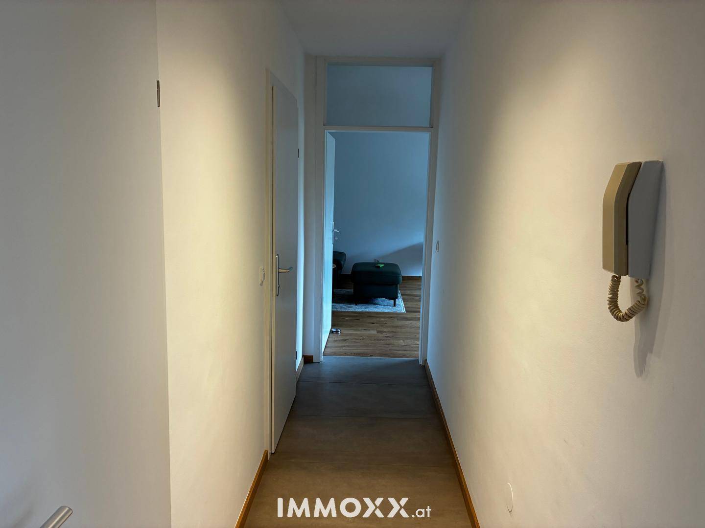 Heller Flur mit Holzboden, der zu den verschiedenen Räumen der Wohnung führt.