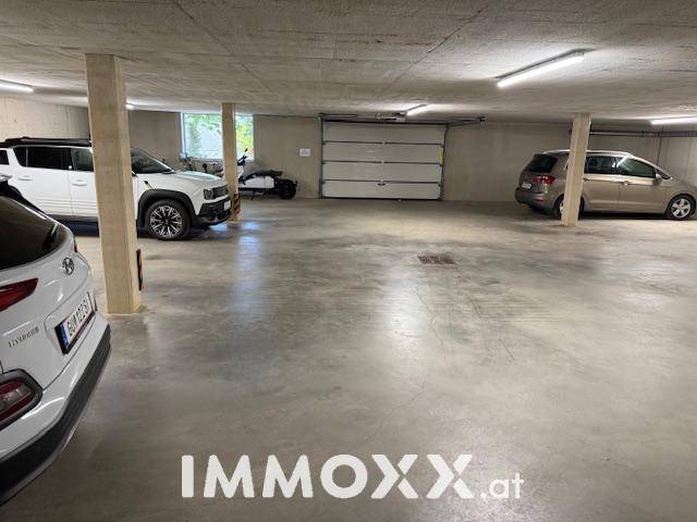 Geräumige Tiefgarage mit mehreren Stellplätzen und Betonboden.
