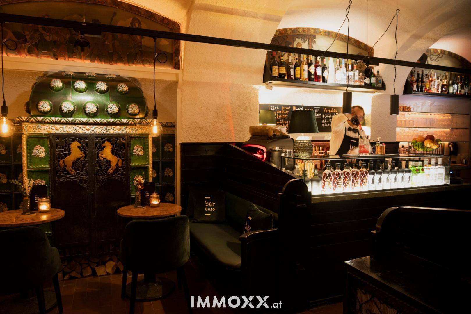 Detailansicht der Bar mit einem kunstvoll gefliesten Ofen und einer gut bestückten Theke.