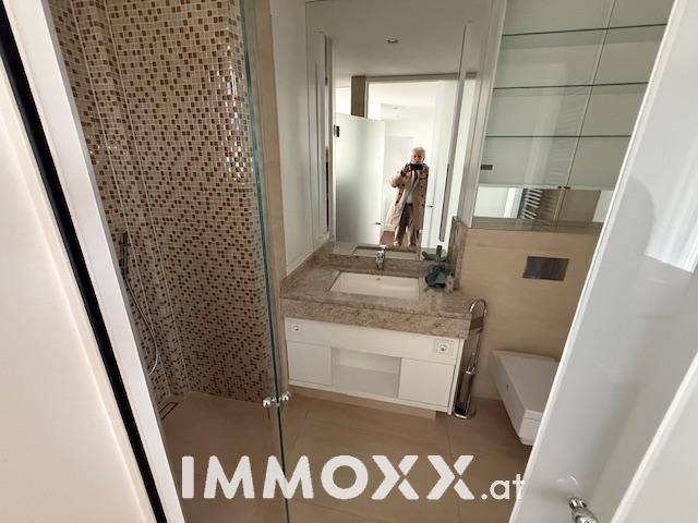 Modernes Badezimmer mit Duschkabine, Einzelwaschbecken und Spiegelschrank.