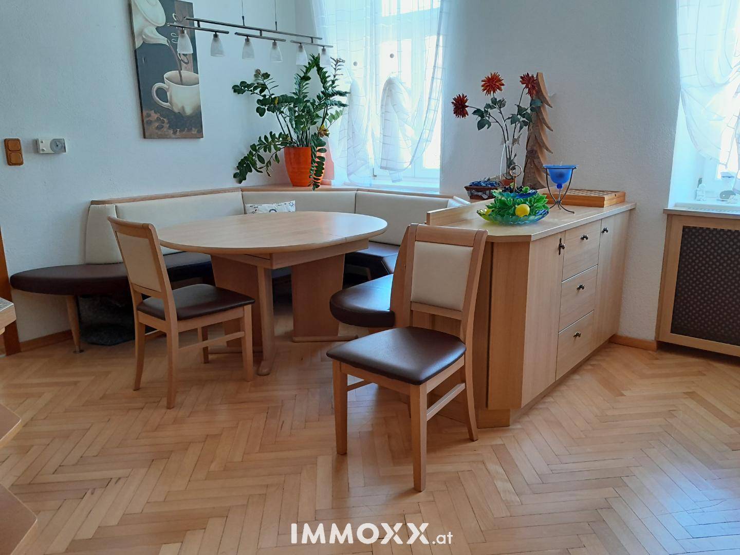 Gemütlicher Essbereich mit Eckbank, rundem Holztisch und hellem Parkettboden.