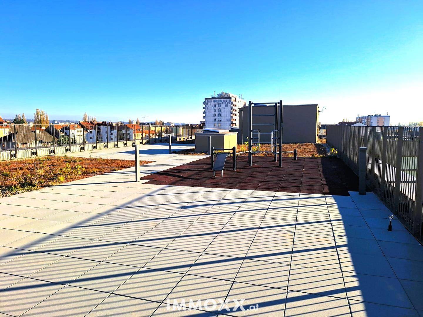 Dachterrasse mit Sportgeräten und weitem Blick über die umliegende Bebauung.