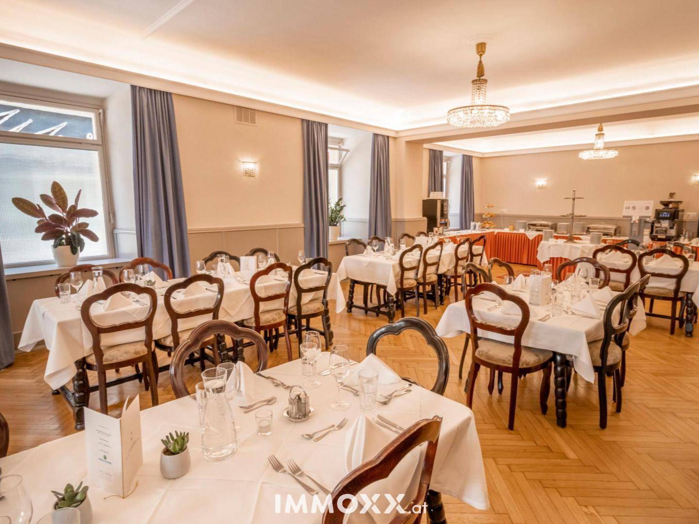 Großer Speisesaal mit elegant gedeckten Tischen, klassischen Holzstühlen und Fischgrätparkettboden.