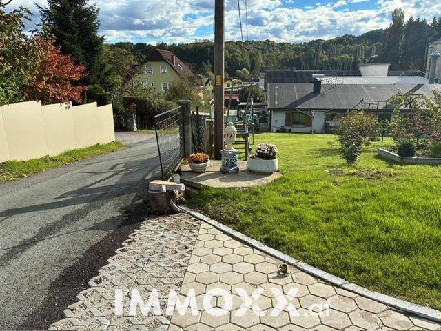 Weitläufiger Gartenbereich mit Rasenfläche, angrenzender Straße und Blick auf die ländliche Umgebung.