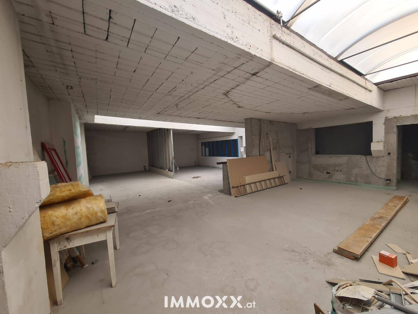 Weiterer Blick in den unfertigen Innenraum mit Baustoffen und Tageslicht durch das Dachfenster.
