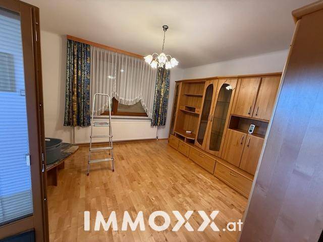 Wohnzimmer mit Holzboden und großer Schrankwand, bietet viel Stauraum und eine gemütliche Atmosphäre.