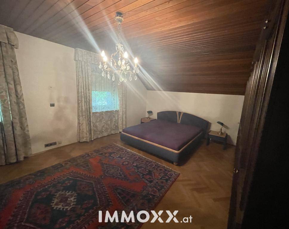 Gemütliches Schlafzimmer im Dachgeschoss mit Parkettboden und schrägen Decken.