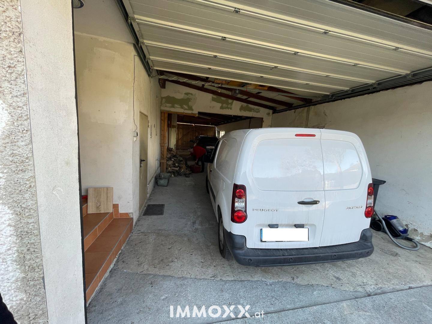 Einfache Garage mit Platz für ein Fahrzeug und direktem Zugang zum Haus.
