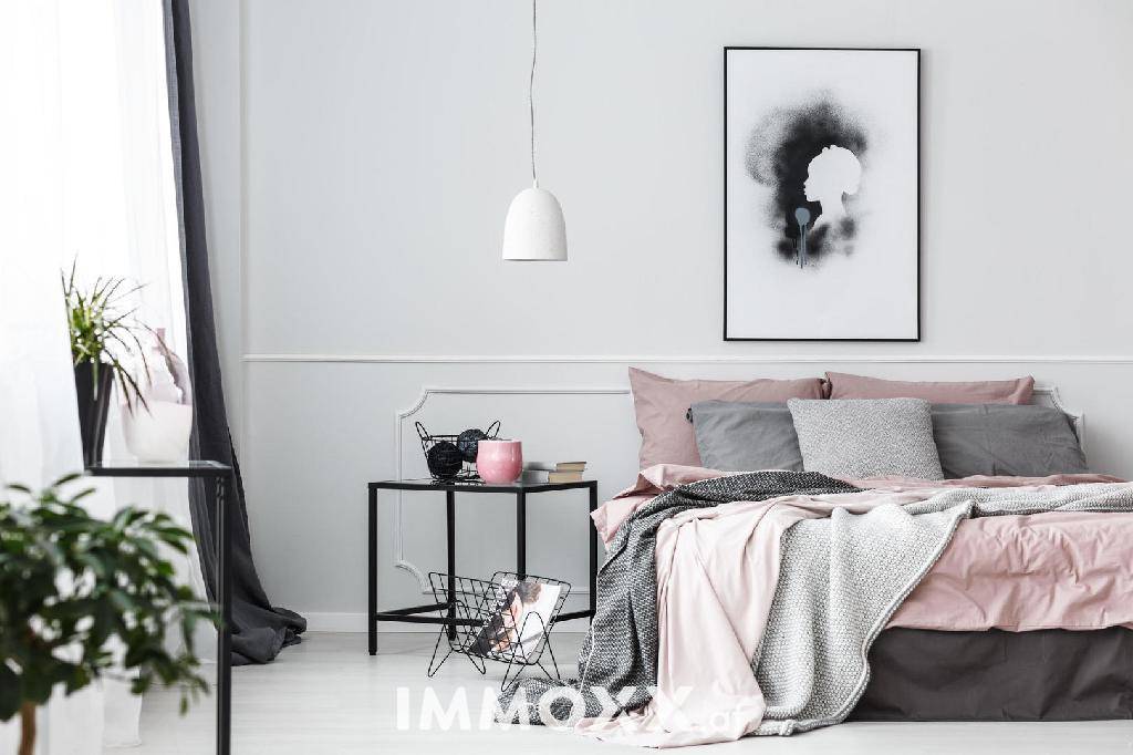 Modernes Schlafzimmer mit hellgrauen Wänden, rosa Bettwäsche und minimalistischer Dekoration.