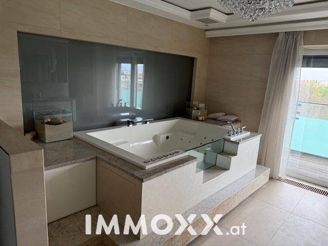 Luxuriöses Badezimmer mit eingebauter Whirlpool-Badewanne und Zugang zur Terrasse.