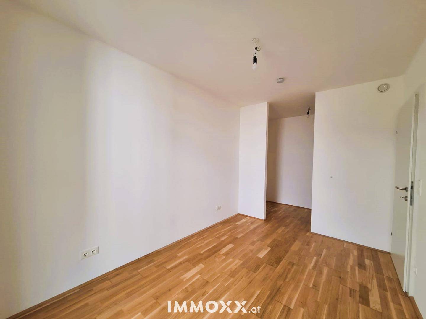 Unmöbliertes Schlafzimmer mit Holzboden und weißen Wänden, bietet viel Gestaltungspotenzial.
